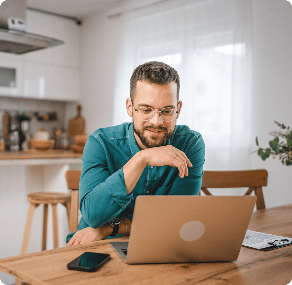 Man smiling while using a laptop